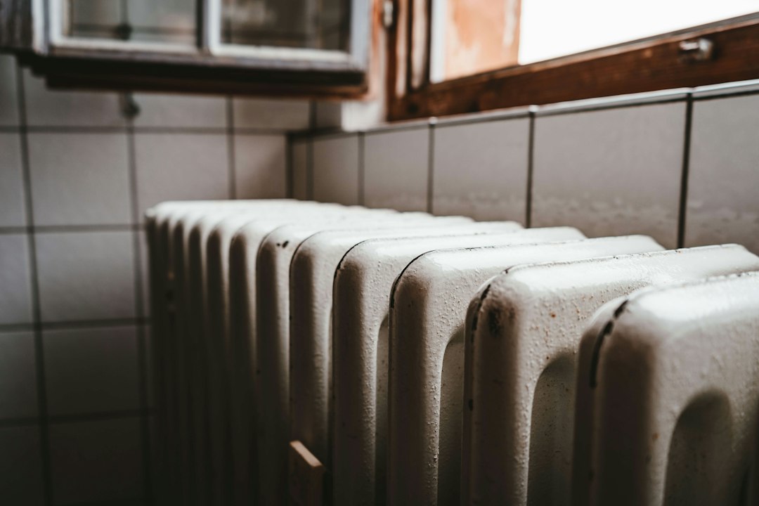 White cast-iron radiator installed beneath a window.